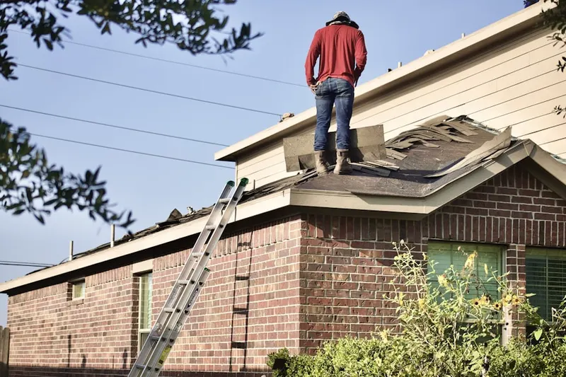 Professional roofer working on a residential roof in Eola
